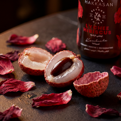 Lychee fruit cut open with lychee hibiscus Kombucha in the background